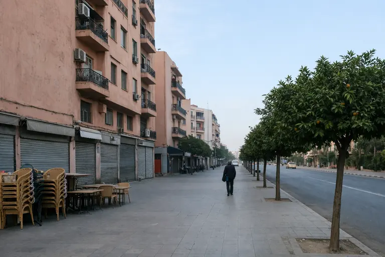 Illustration : trottoir de Guéliz à Marrakech tôt le matin, façades rose ocre et orangers