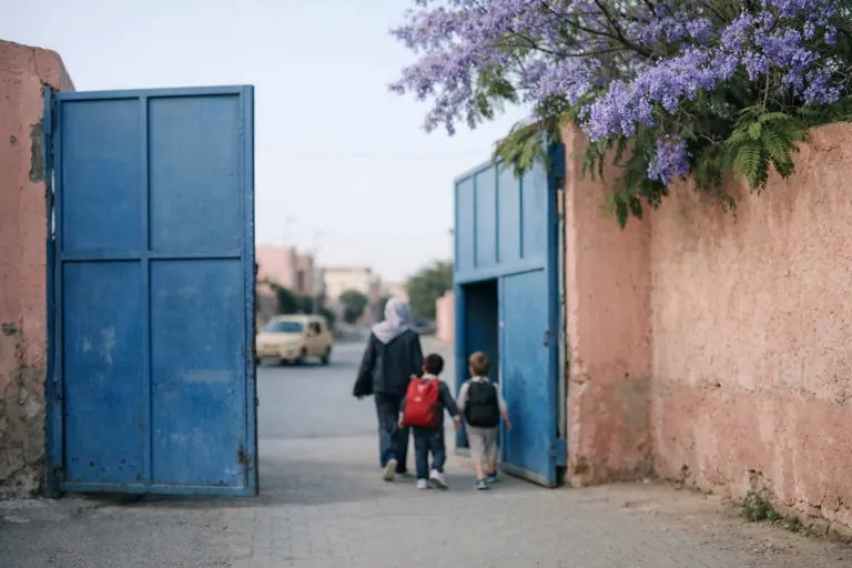 Illustration : portail bleu d'une école de quartier à Marrakech, un matin de rentrée